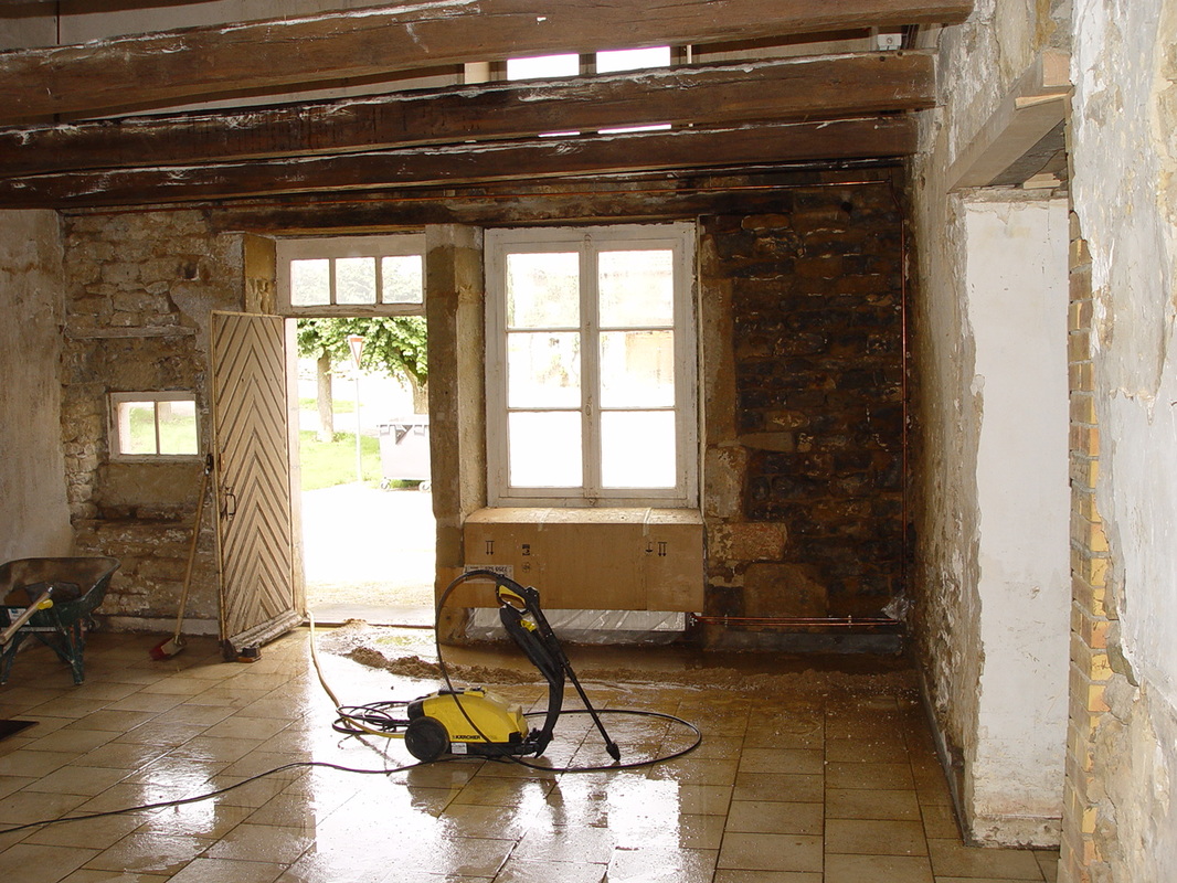afb. 07.2 - 17 De muur is afgebikt en wordt nu schoongespoten. Let op de afvoer van het water door een dijkje naar buiten.